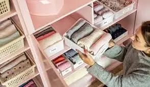 Gavetas com organizadores e roupas dobradas na vertical